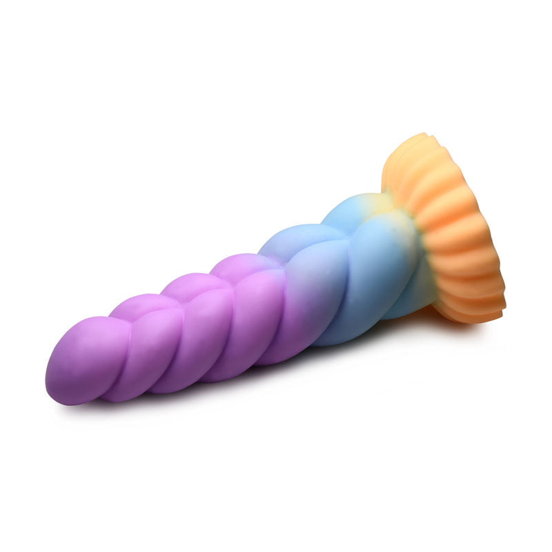 The Creature Cocks Mystique Silicone Unicorn Dildo is a whimsical 21 cm fantasy toy with a gradient of purple, blue, and yellow on its horn-shaped body. It features an orange ribbed suction cup base and has a smooth, glossy surface, perfect as a vibrant decorative piece.