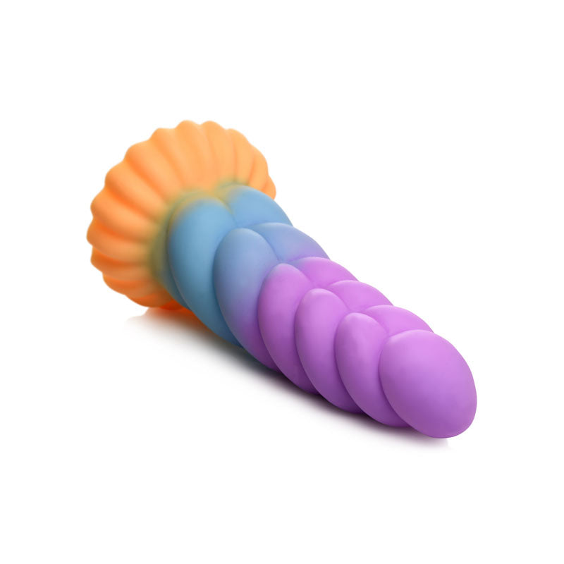 The Creature Cocks Mystique 21 cm Fantasy Dildo has a colorful, swirled, tapered design inspired by a unicorn horn. With a gradient of purple to blue and an orange scalloped base, its smooth surface has pronounced ridges for a whimsical look, plus it features a suction cup base.