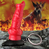 The Creature Cocks Hell-Hound Keychain features a red and black fantasy creatures horn on a rocky base, with a detachable keyring. A horned canine monster stands amidst flames against a fiery sky, creating an intense mythical atmosphere.