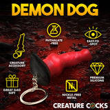 The Creature Cocks Hell-Hound Keychain is a red and black dog-shaped accessory against a dark red background. It features Phthalate-Free, Easy-to-Spot, and Premium Silicone qualities, making it ideal for fantasy roleplay or as a Great Gag Gift.