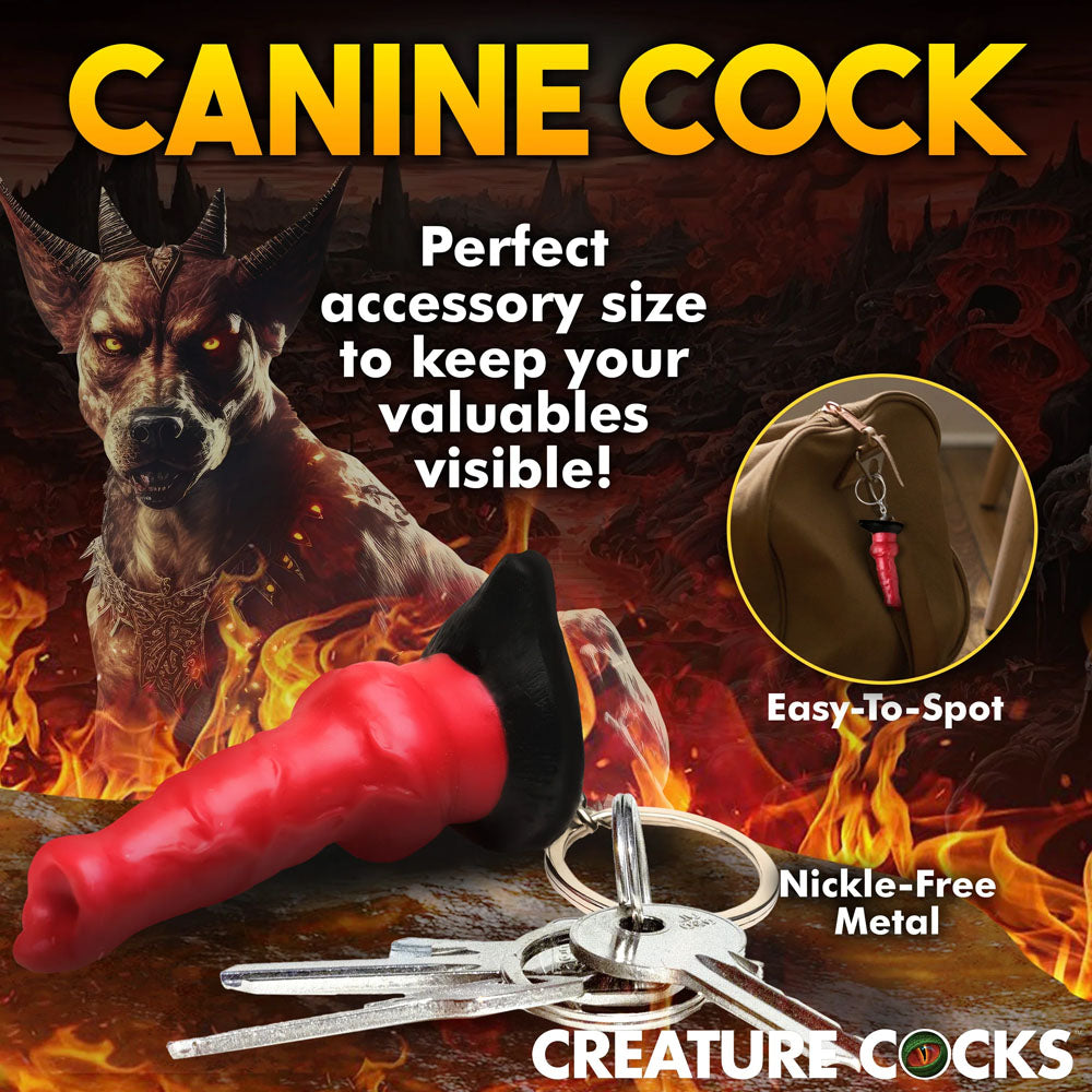 The Creature Cocks Hell-Hound Keychain is a red, dog-shaped novelty keychain featuring a fiery landscape with a demonic dog figure. Boldly boasts Easy-to-Spot design and Nickel-Free Metal. Ideal for horror fantasy lovers, it appears on a brown bag in the insets.