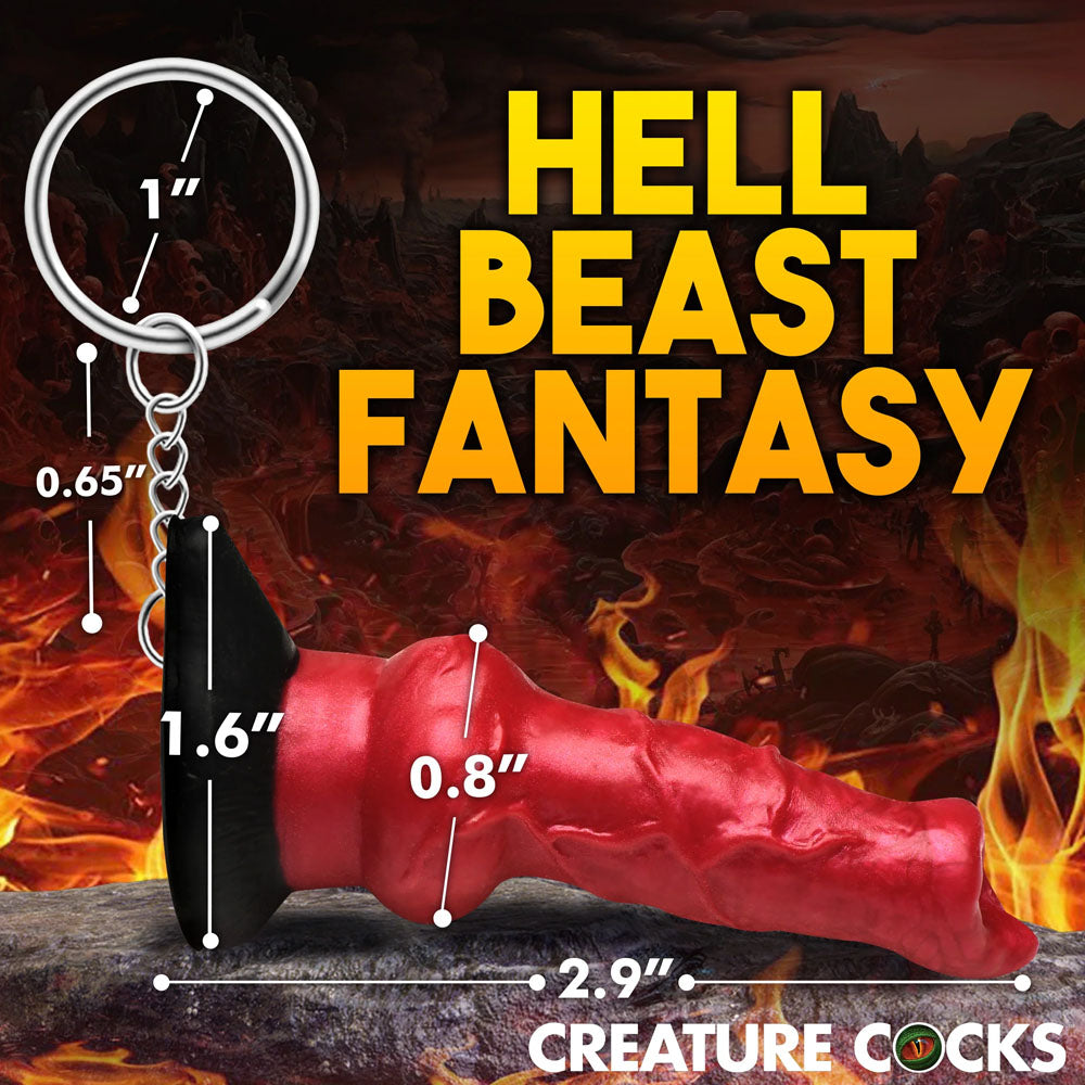 The Creature Cocks Hell-Hound Keychain features a red, horn-like novelty fantasy dildo against a fiery backdrop with HELL BEAST FANTASY and CREATURE COCKS text. Perfect for horror enthusiasts or fantasy roleplayers, it measures 2.9 inches and includes loops for easy attachment.