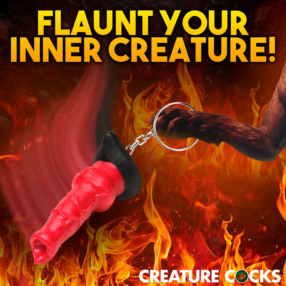 The Creature Cocks Hell-Hound Keychain, a red, textured fantasy-themed novelty dildo keyring, is showcased against flames with the text Flaunt Your Inner Creature! above and Creature Cocks below—ideal for mythical erotica aficionados.