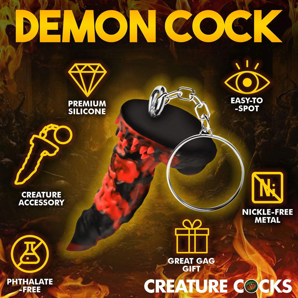 The Creature Cocks Fire Demon Keychain features a black and red silicone demon-like design, ideal for fantasy roleplay. Made with Premium Silicone, its Phthalate-Free, Nickel-Free, and a perfect gag gift, with flames in the background enhancing its mythical appeal.