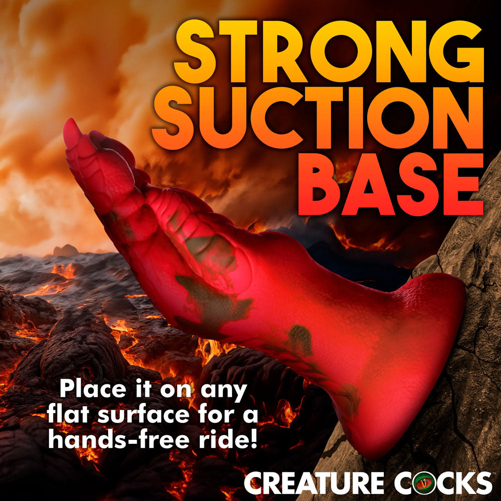 A red, textured Creature Cocks Demon Claw Fisting Silicone Dildo with a strong suction base stands out against a fiery backdrop. Perfect for fantasy roleplay and hands-free thrill on any flat surface, its strength and durability evoke the allure of demon claws.