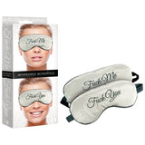 The Fuck Me/Fuck You Padded Reversible Blindfold features fun embroidery, with Fuck Me on one side and Fuck You on the other. It is shown outside packaging, revealing both phrases on the comfortable fitting blindfold, modeled with a smile on the daring Fuck Me side.