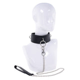 The EDGE Collar & Leash is exhibited on a white mannequin bust, showcasing a padded black faux leather design with metal rings and a central loop connecting to a detachable silver chain leash. The leash has a black loop handle, and the mannequin lacks facial features.