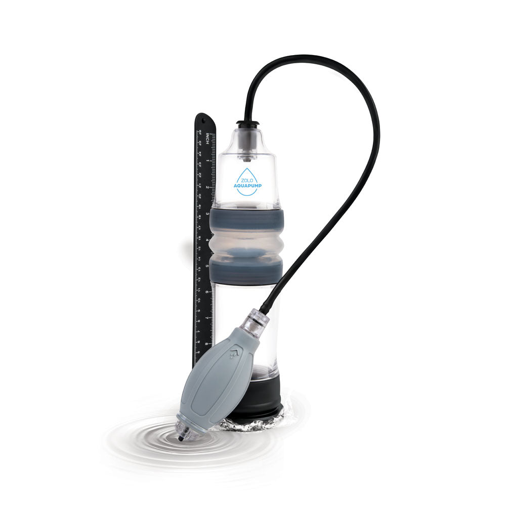 The Zolo Aquapump Compact - Clear Water Penis Pump is a portable filtration device with a waterproof design. It features a manual pump and black hose connected to a clear, accordion-style container marked for 12 inches, suitable for any adventure on ripple-strewn white surfaces.