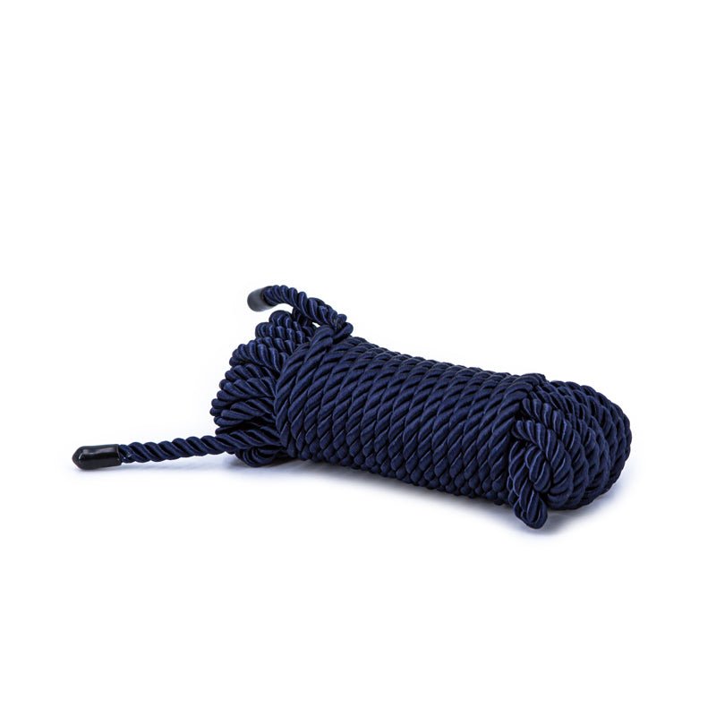 A neatly coiled bundle of the Bondage Couture Rope - Blue lies on a plain white background. With a twisted design and capped ends, it appears thick and durable, making it the ultimate accessory for heavy-duty tasks.