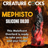 The Creature Cocks Mephisto Dildo, in fiery red and black premium silicone, is set against a blazing backdrop with the text: CREATURE COCKS, SILICONE DILDO. Let this Maleficent Overlord capture your soul and your senses!.