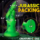 The Creature Cocks Raptor Claw Fisting Silicone Dildo in green, with an 8.6 height and 7.4 insertable length, is ideal for fantasy roleplay against a dark stone archway. Topped by JURASSIC PACKING, its textured, dinosaur-themed design makes it a standout centerpiece.