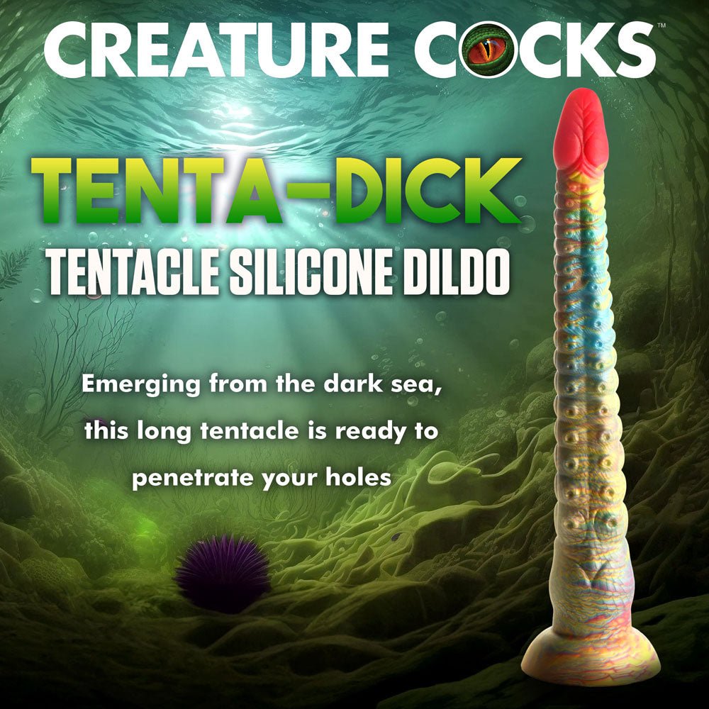 A multi-colored, 32 cm Creature Cocks Tenta-Dick silicone tentacle dildo with a strong suction-cup base stands upright in an underwater setting with seaweed, rocks, and a sea urchin illuminated by sunlight. Text reads Creature Cocks on this phthalate-free fantasy product.